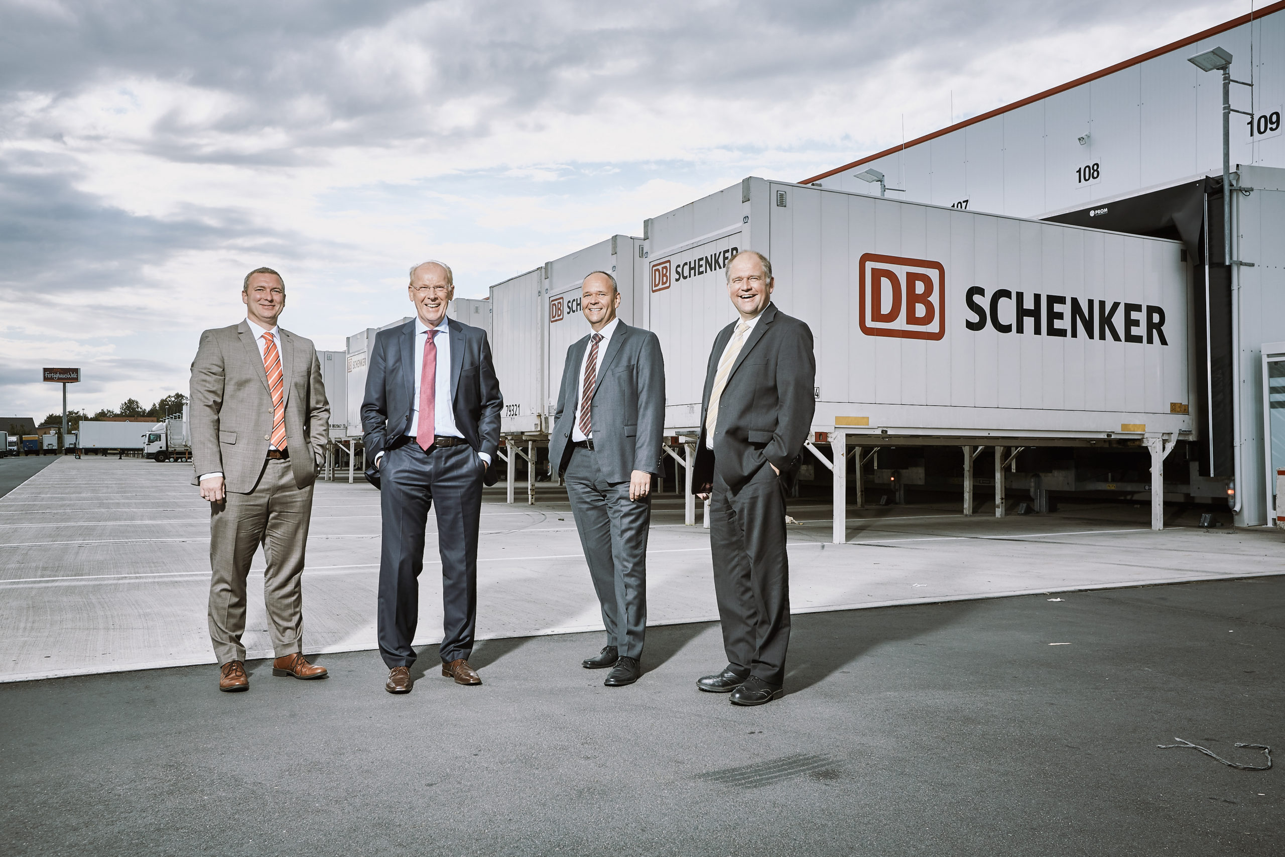 vier Männer posieren für ein Portrait auf DB Schenker Betriebsgelände
